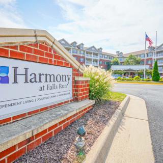 Entrance to Harmony at Falls Run Apartments with signage and landscaping.