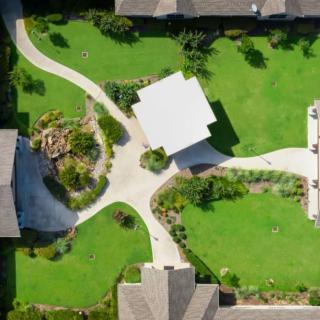 Aerial view of a landscaped garden with pathways and surrounding buildings.