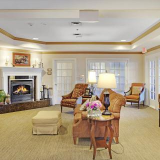 A cozy living room featuring a warm fireplace, comfortable seating, and elegant decor.