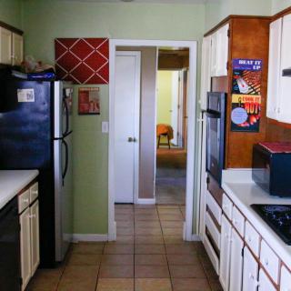 A cozy kitchen with various appliances and white cabinetry.