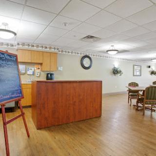 A cozy community room featuring a kitchenette and a dining area, perfect for gatherings.