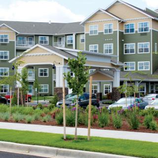 A modern residential apartment building with landscaped grounds and parking.