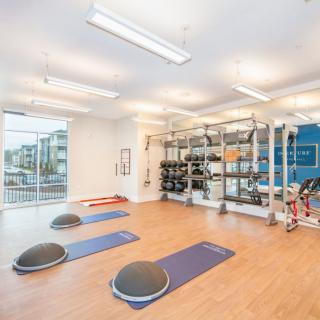 A spacious fitness center with exercise equipment and bright natural lighting.