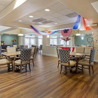 A neatly arranged dining area with patriotic decorations and wooden flooring.