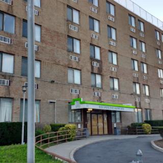 A view of a hotel building showcasing the entrance and surrounding area.