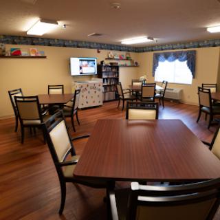 A cozy dining area featuring tables and chairs, designed for community gatherings.