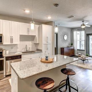 A modern open-concept kitchen with a central island and stylish pendant lighting, seamlessly connected to a cozy living area.