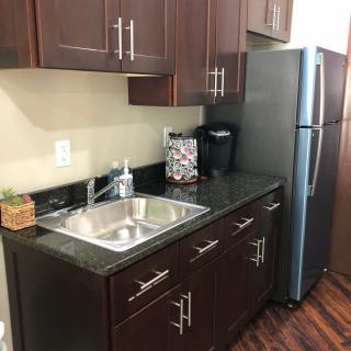 Modern kitchen with dark cabinets and stainless steel appliances.