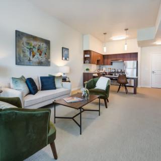 A modern open-concept living room and kitchen with stylish furniture and decorative artwork.