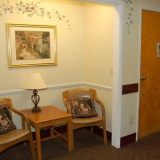 A cozy waiting area with chairs, a small table, and decorative elements.