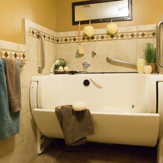 An accessible bathroom with a specialized bathtub, towels, and decorative elements.