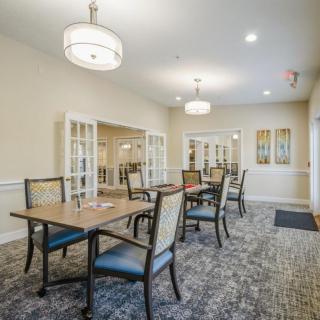 Elegantly designed dining area with tables and chairs set under modern lighting.