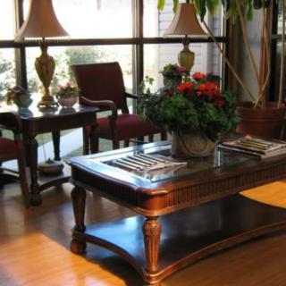 A cozy living room with elegant furniture and decorative plants.