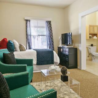 A cozy living space with a bed, seating area, and television.