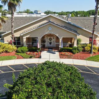 Front view of a building with a landscaped entrance and palm trees.