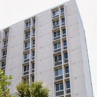 A view of a modern residential building with multiple windows and a minimalist design.