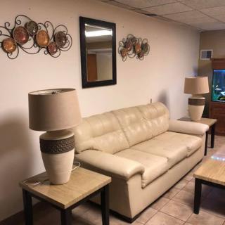 A cozy living room with a beige sofa, lamps on side tables, decorative wall art, and a mirror.