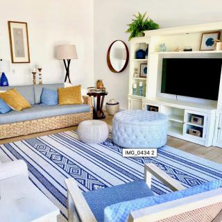 A cozy living room with a blue and white color scheme, featuring a comfortable sofa, decorative cushions, and a stylish rug.