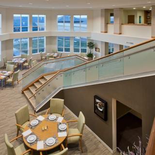 A modern interior with a spacious dining area and stylish staircase.