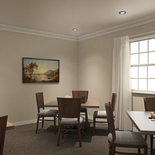 A cozy dining room with a table, chairs, and artwork on the wall.
