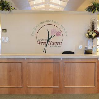 A welcoming reception area with a floral theme and wooden furniture.