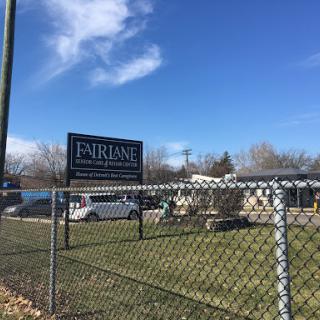 A view of a fenced area with a sign under a clear blue sky.