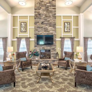 A cozy living room with a stone fireplace, comfortable seating, and elegant decor.