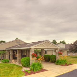 A charming house with well-maintained landscaping under a cloudy sky.