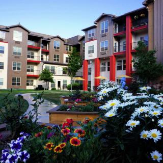 A beautifully landscaped apartment complex with vibrant flower gardens.