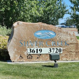 A stone sign displaying the addresses 3619 and 3720, located in a grassy area with trees in the background.