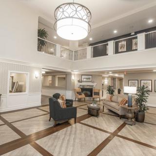 A modern hotel lobby with elegant furnishings and a large chandelier.