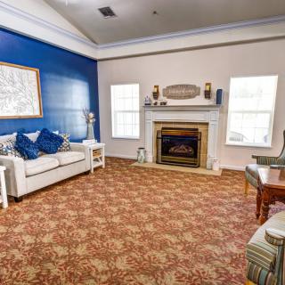 A cozy living room with a blue accent wall, featuring a sofa and fireplace.