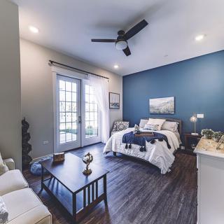 A modern bedroom with a blue accent wall, featuring stylish furniture and a cozy atmosphere.