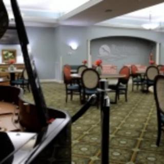 A cozy dining area with a grand piano and elegant seating arrangement.