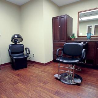 An interior view of a hair salon with styling chairs and a mirror.