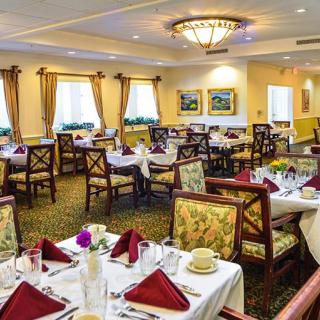 An elegantly set dining room with neatly arranged tables and chairs.
