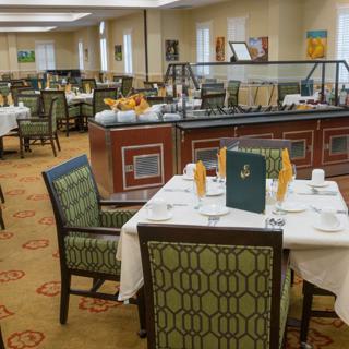 An elegant dining area with neatly arranged tables and a buffet section.
