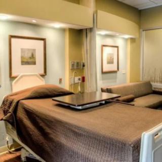 A clean and well-equipped hospital room with a patient bed and medical devices.