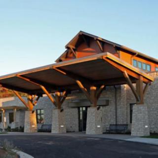 A modern building entrance featuring a wooden canopy and stone exterior.