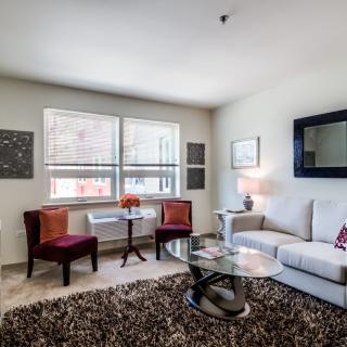 A modern living room with stylish furniture and decor, featuring a comfortable sofa, armchairs, and a glass coffee table.