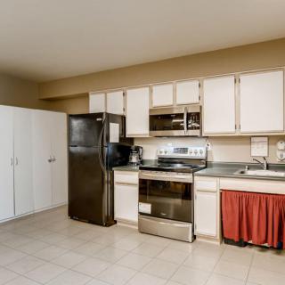 A modern kitchen featuring stainless steel appliances and white cabinets.