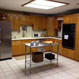 A spacious kitchen with wooden cabinets, stainless steel appliances, and a central island.