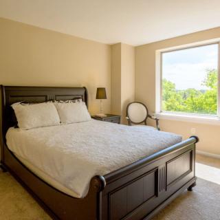 A cozy bedroom with a large window allowing natural light to fill the space.