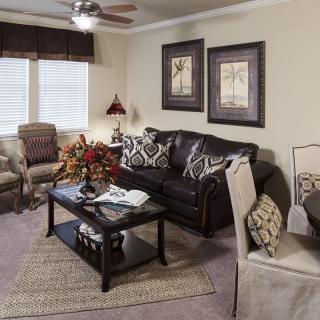 A cozy living room with a sofa, armchairs, and a coffee table adorned with decorations.