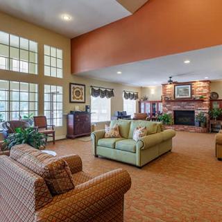 A spacious living room with comfortable seating, a fireplace, and large windows.