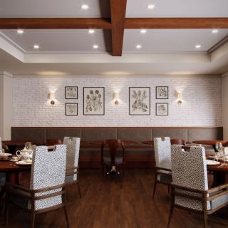 A cozy restaurant interior featuring neatly arranged tables and chairs with artwork adorning the walls.