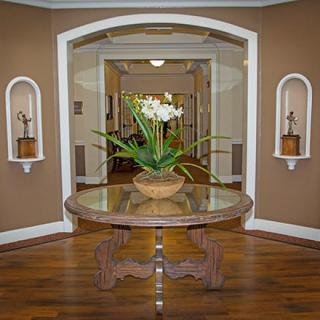 A beautifully decorated hallway with a round table featuring a plant centerpiece.