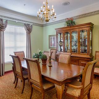 A classic dining room with wooden furniture and a chandelier.