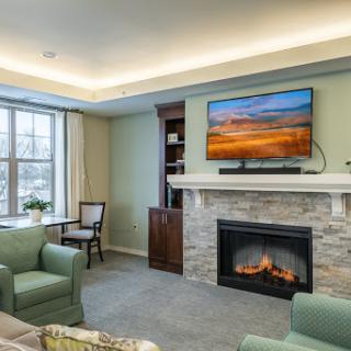 A cozy and modern living room featuring a fireplace and a mounted television.