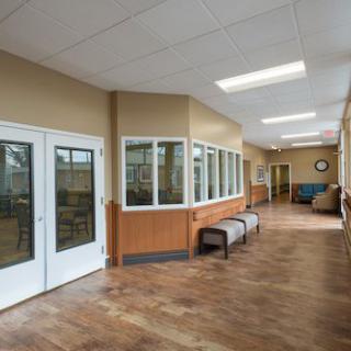 A quiet, well-lit hallway with benches and large windows in a commercial space.